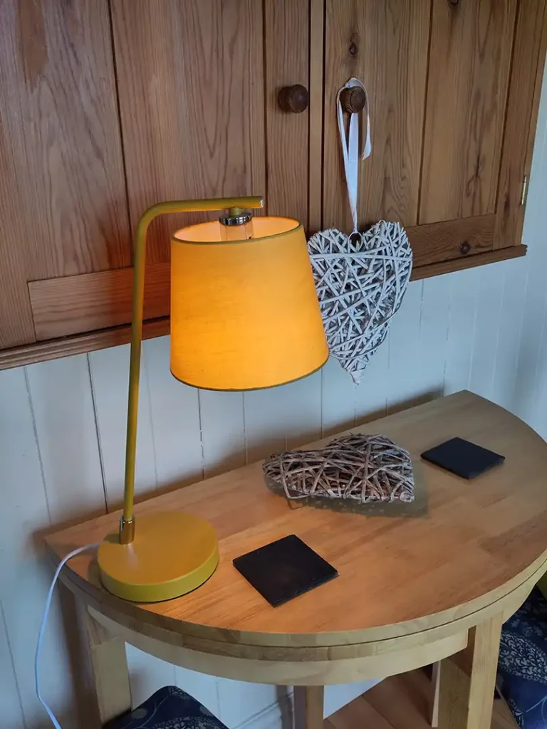 A warm bedside lampat Eastleach Downs Organic Farm Shepherd's Hut, Gloucestershire